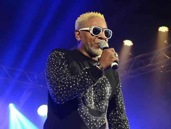Awilo Longomba performing live on stage with a microphone