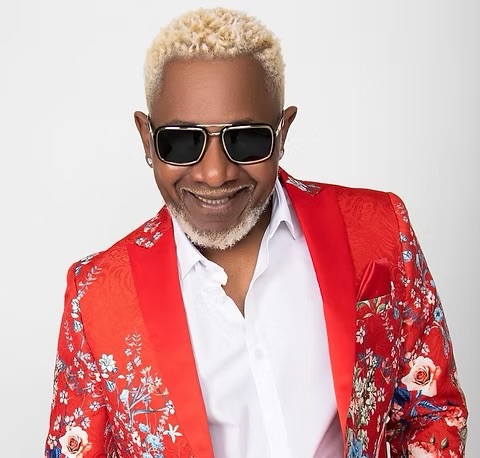 Awilo Longomba portrait wearing a red floral jacket